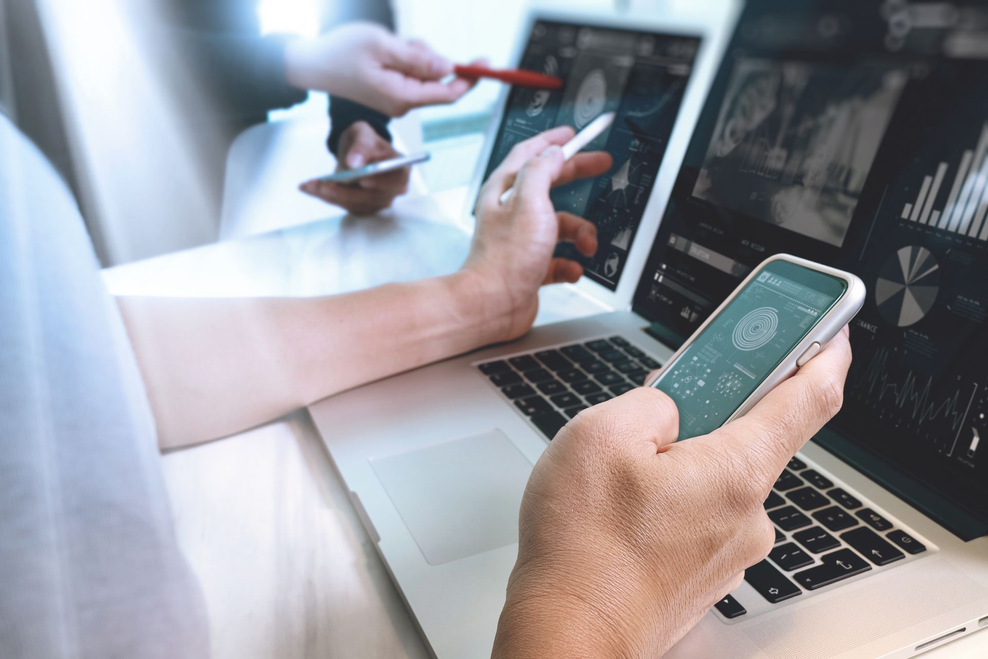 Woman's hands testing a website on tablet, desktop and mobile