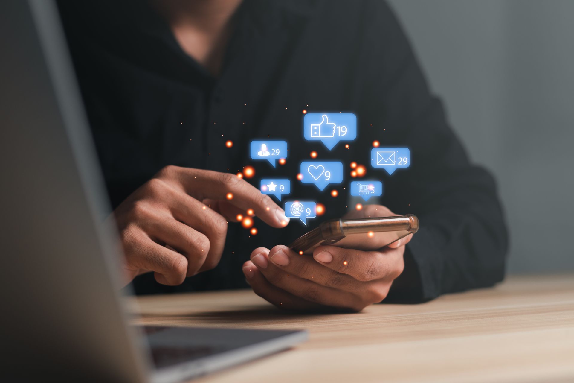 Woman holding smartphone with social media like symbols coming out of the screen