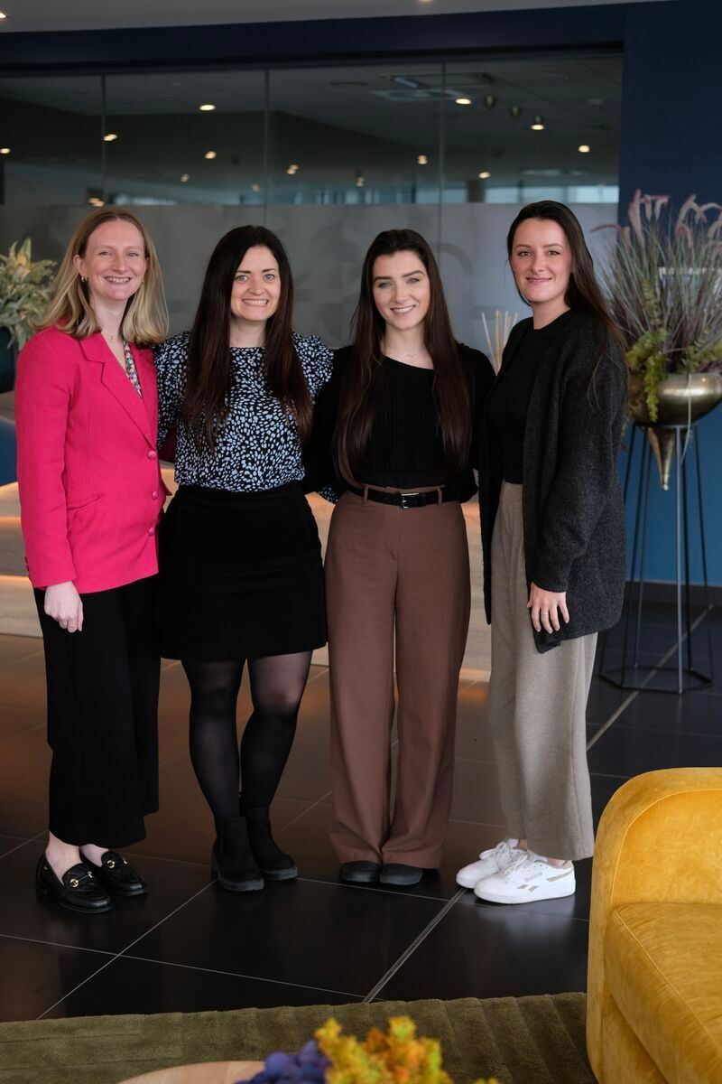 A group of women are posing for a picture in a room.