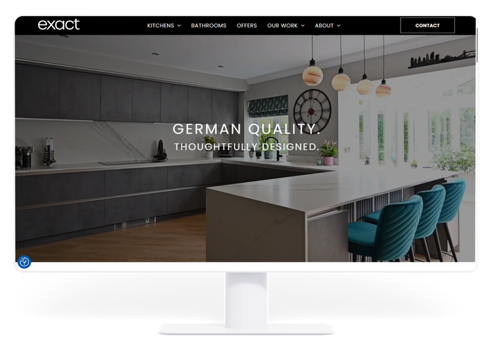 Modern kitchen website homepage with dark cabinetry, white island, teal stools, and pendant lights