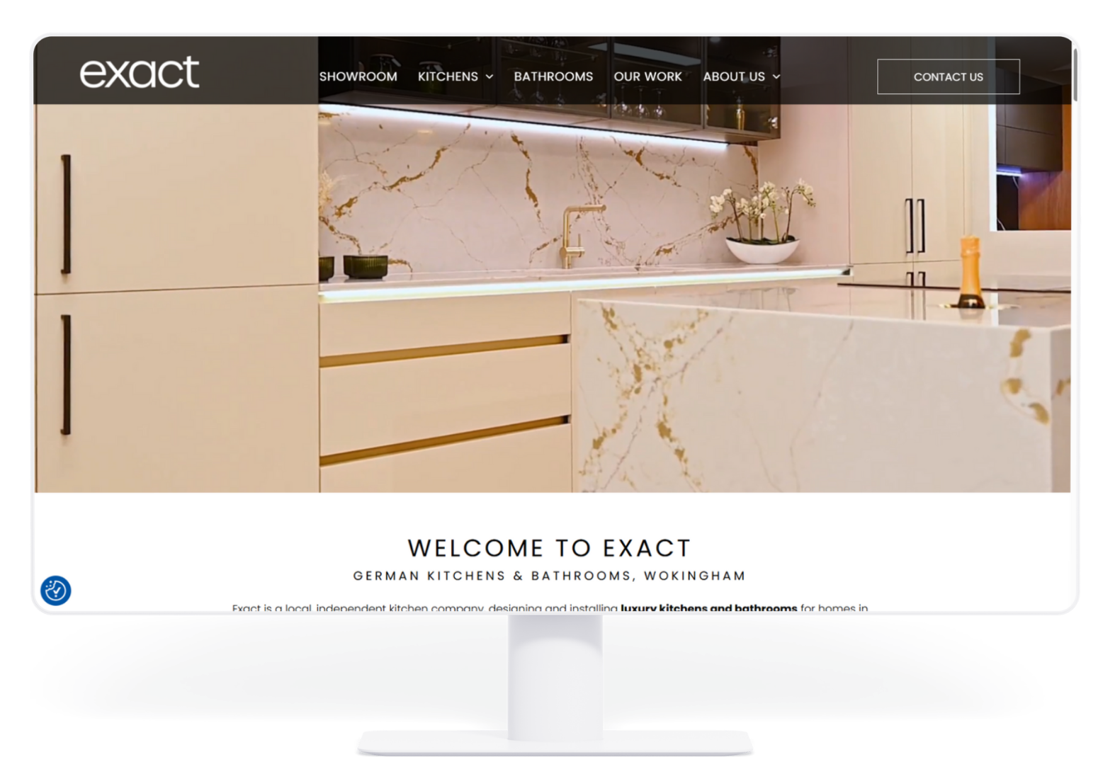 Website for Exact, showing a modern kitchen with light-colored cabinets, marble countertops, and gold fixtures.