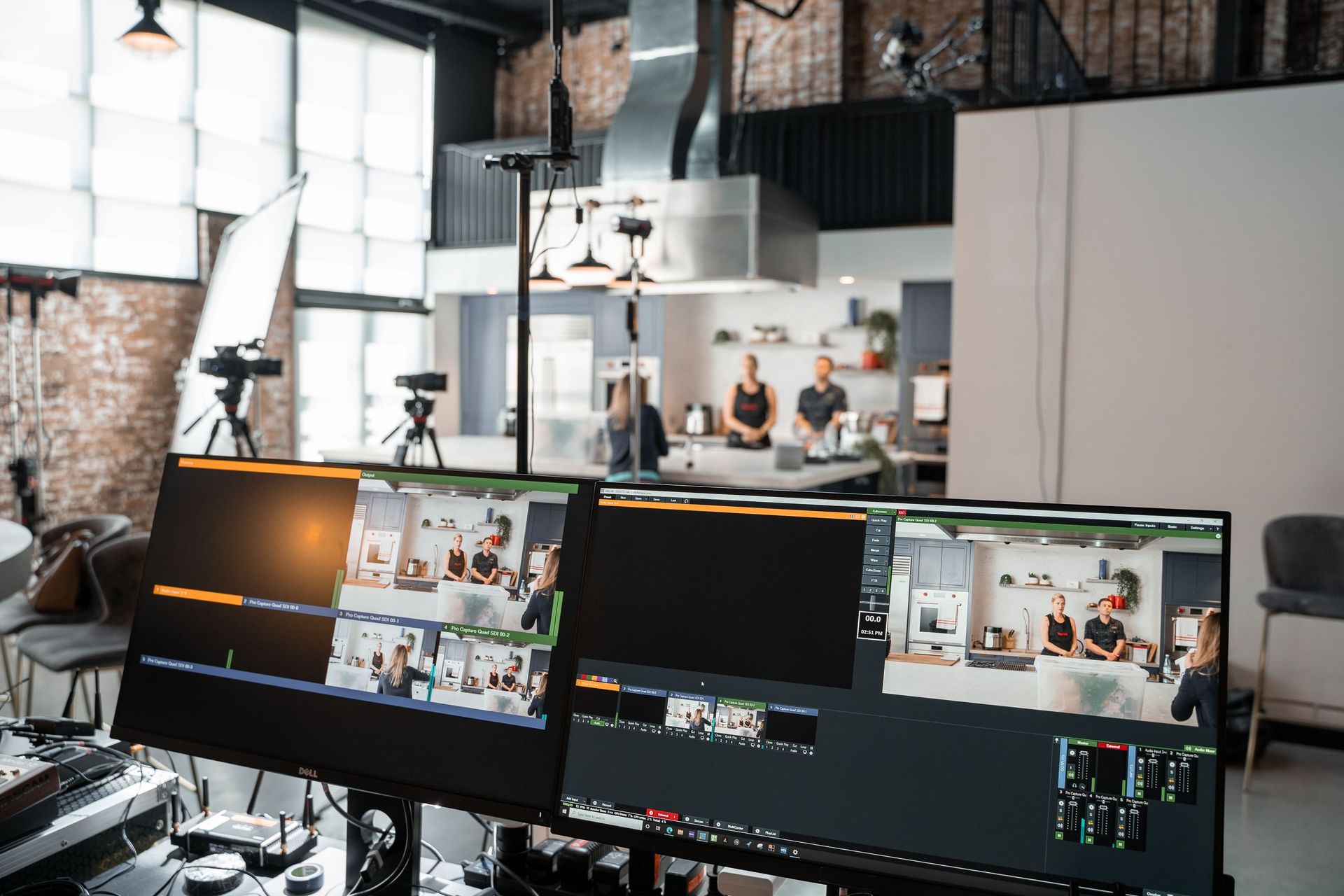 Live streaming studio with multiple monitors showing a video production team in a bright office.