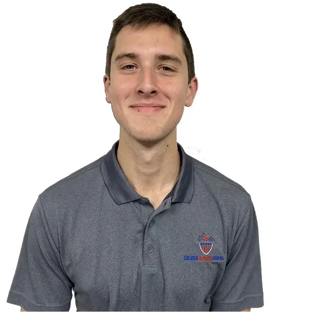Smiling person in a gray polo shirt against a white background