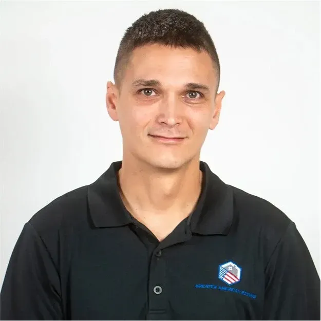 Portrait of a man in a black polo shirt against a white background
