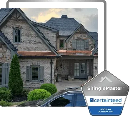 Stone house with dark gray shingle roof and CertainTeed ShingleMaster badge in the corner