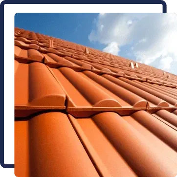 Terracotta roof tiles under a blue sky with clouds