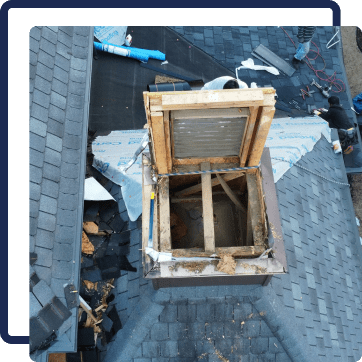 Damaged roof with open chimney or attic vent, broken shingles, and exposed wood framing.