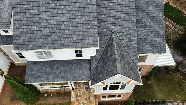 Aerial view of a gray-roofed suburban house with a central gable and brick front entrance.