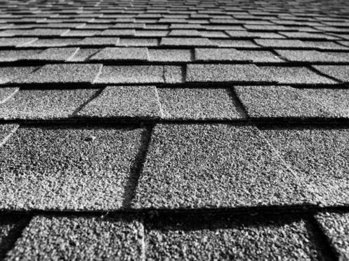 Black-and-white close-up of overlapping roof shingles receding into the distance
