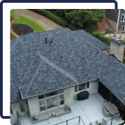 Aerial view of a house with a gray shingle roof and a white wooden deck