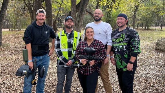 A group of people are posing for a picture in the woods.