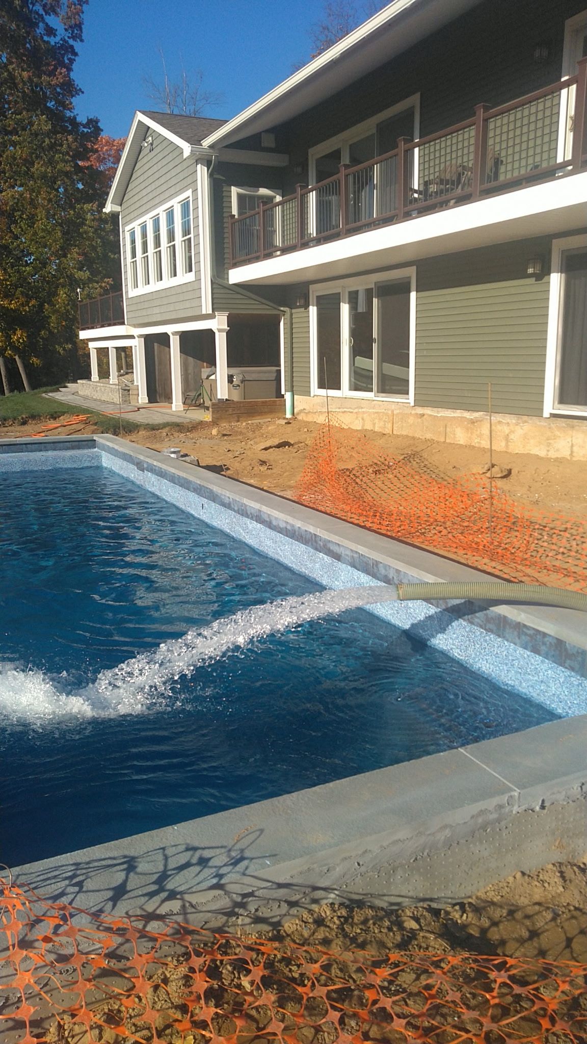 House exterior with a blue swimming pool and water splashing near the edge