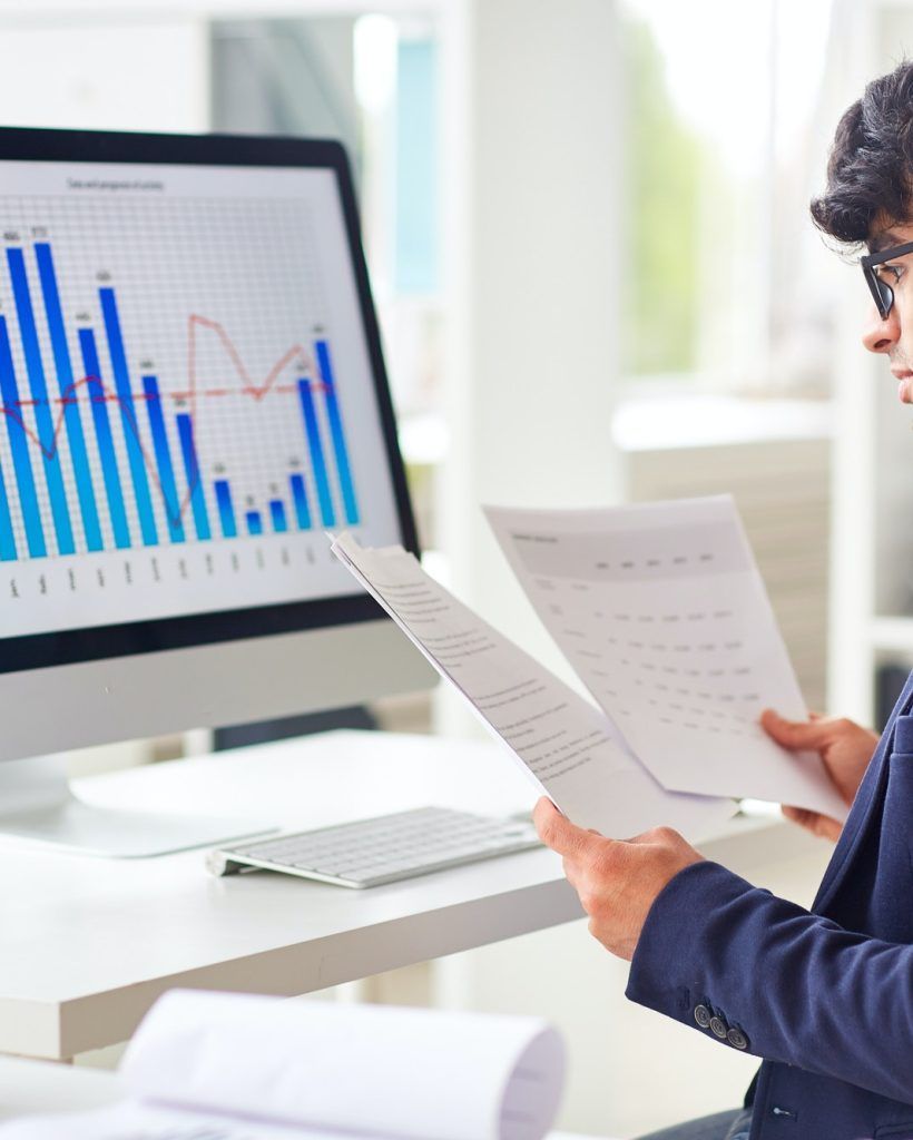 CPA looking at spreadsheets and graphs to provide quality financial guidance to business