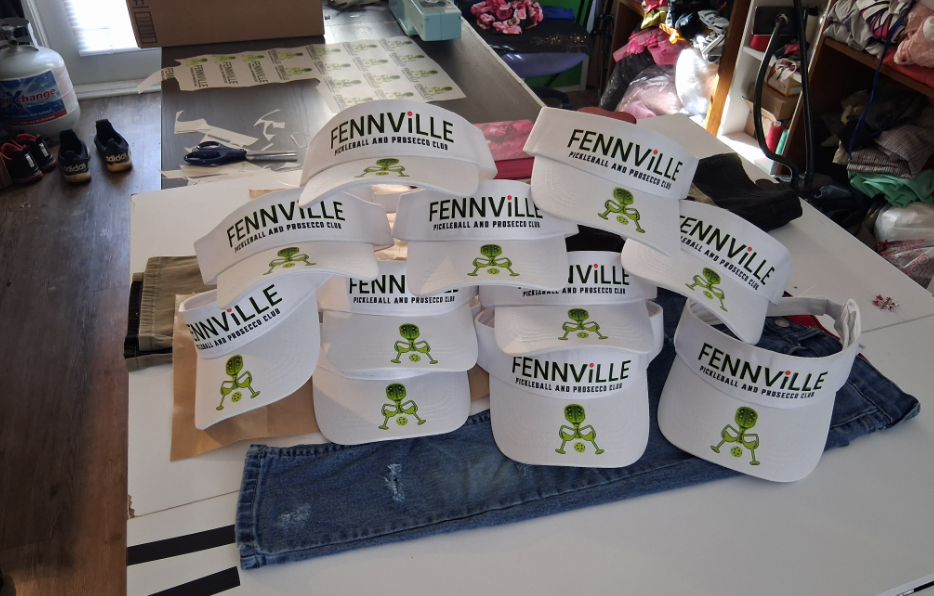 Fennville-branded white paper cups arranged on a table in a store or event setting