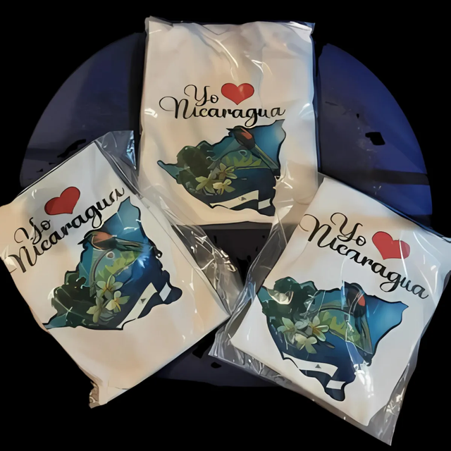 Three “I ♥ Nicaragua” souvenir shirts on a dark round table.