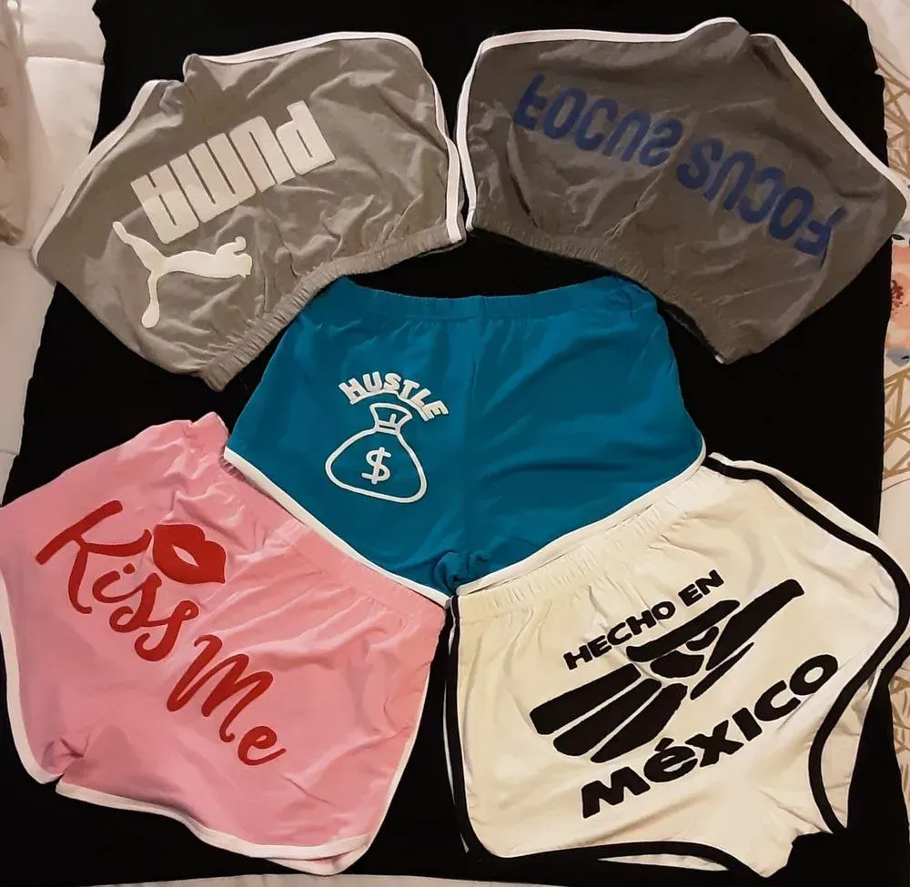 Five colorful boxer shorts arranged in a circle, each with bold printed text on a black background.