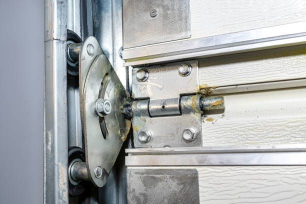 A close up of a garage door with a broken hinge.