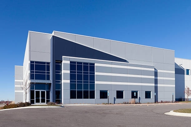 A large building with a lot of windows and a blue sky in the background.
