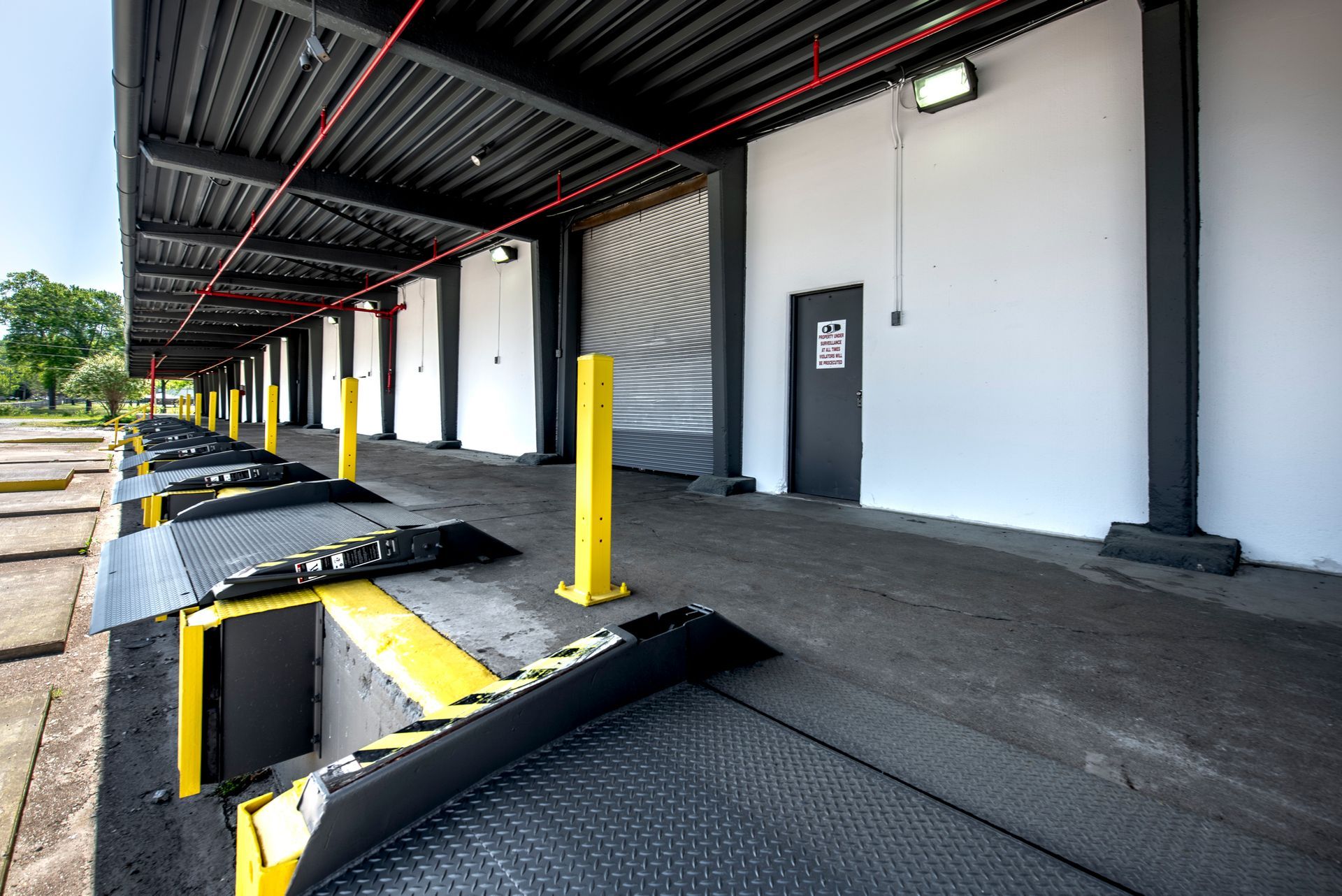 A warehouse with a row of ramps and a door.