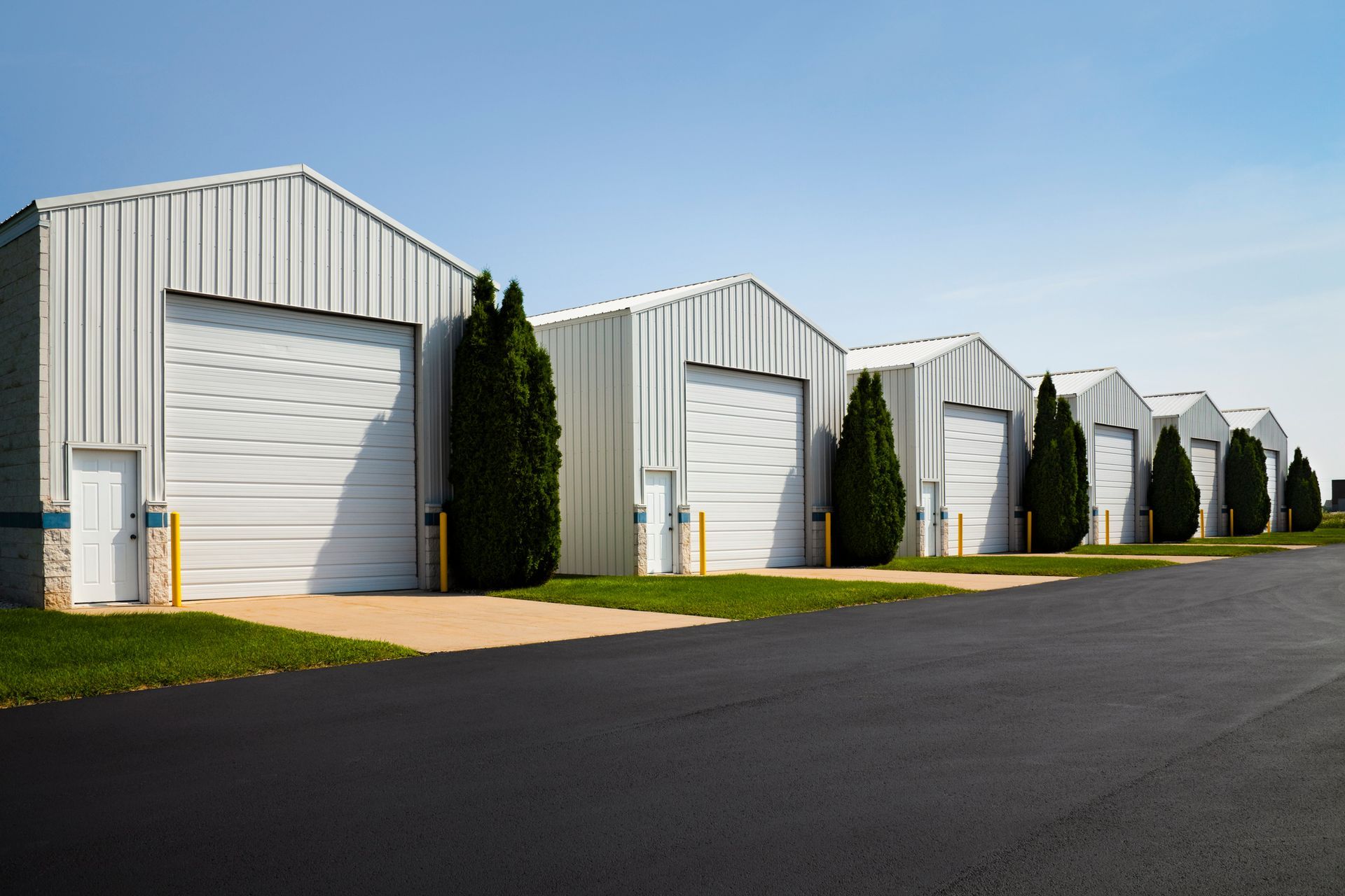 A row of warehouses with white garage doors.