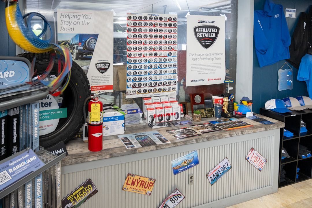 Auto shop counter with racing decals, stacked brochures, tools, and a fire extinguisher