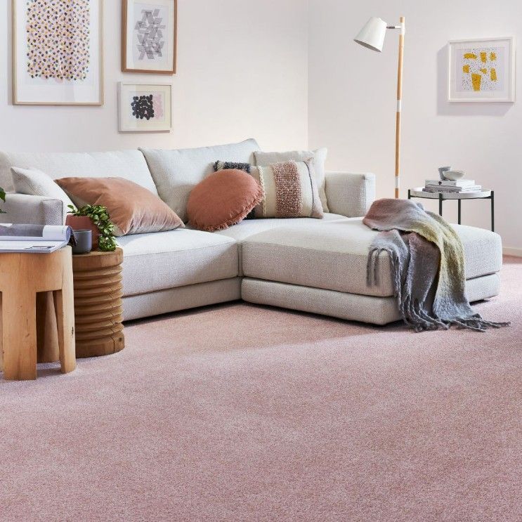 A Living Room With a Sectional Couch and Pink Carpet — Hoppens Floorworld in Mareeba, QLD