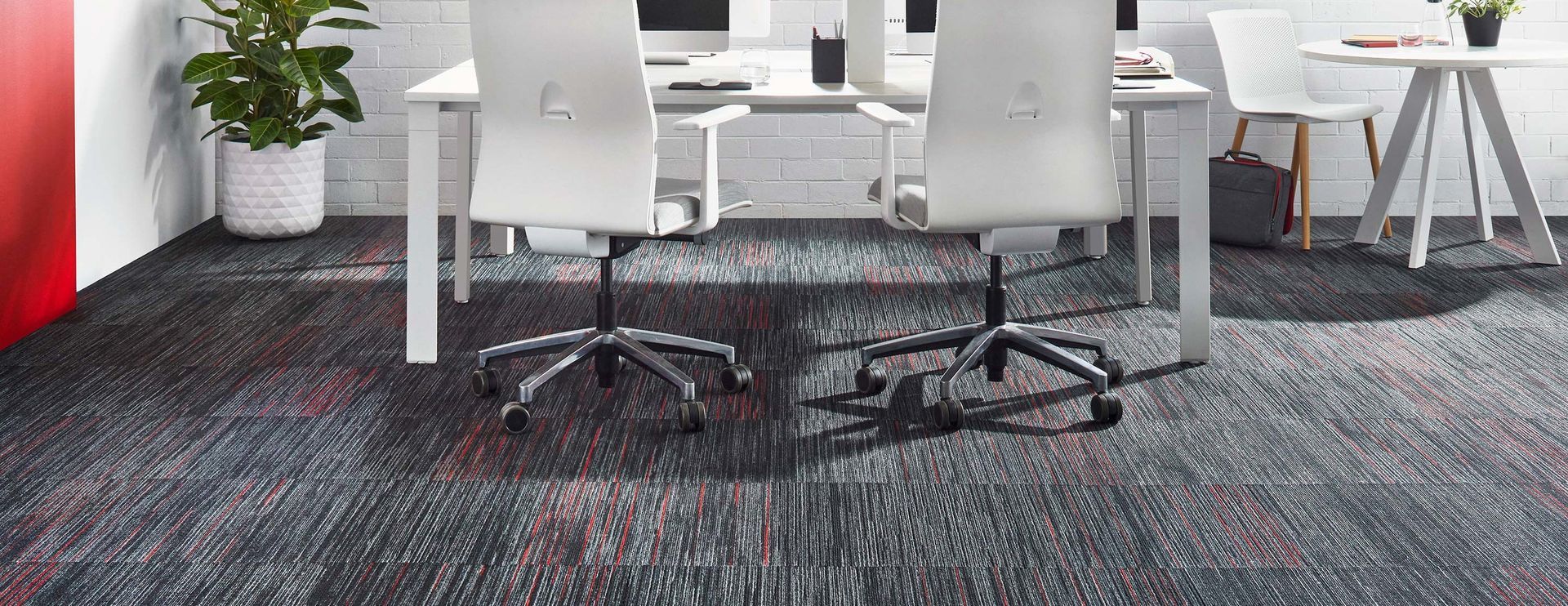 Office meeting area with white chairs around a table and a dark patterned carpet — Hoppens Floorworld in Manunda, QLD