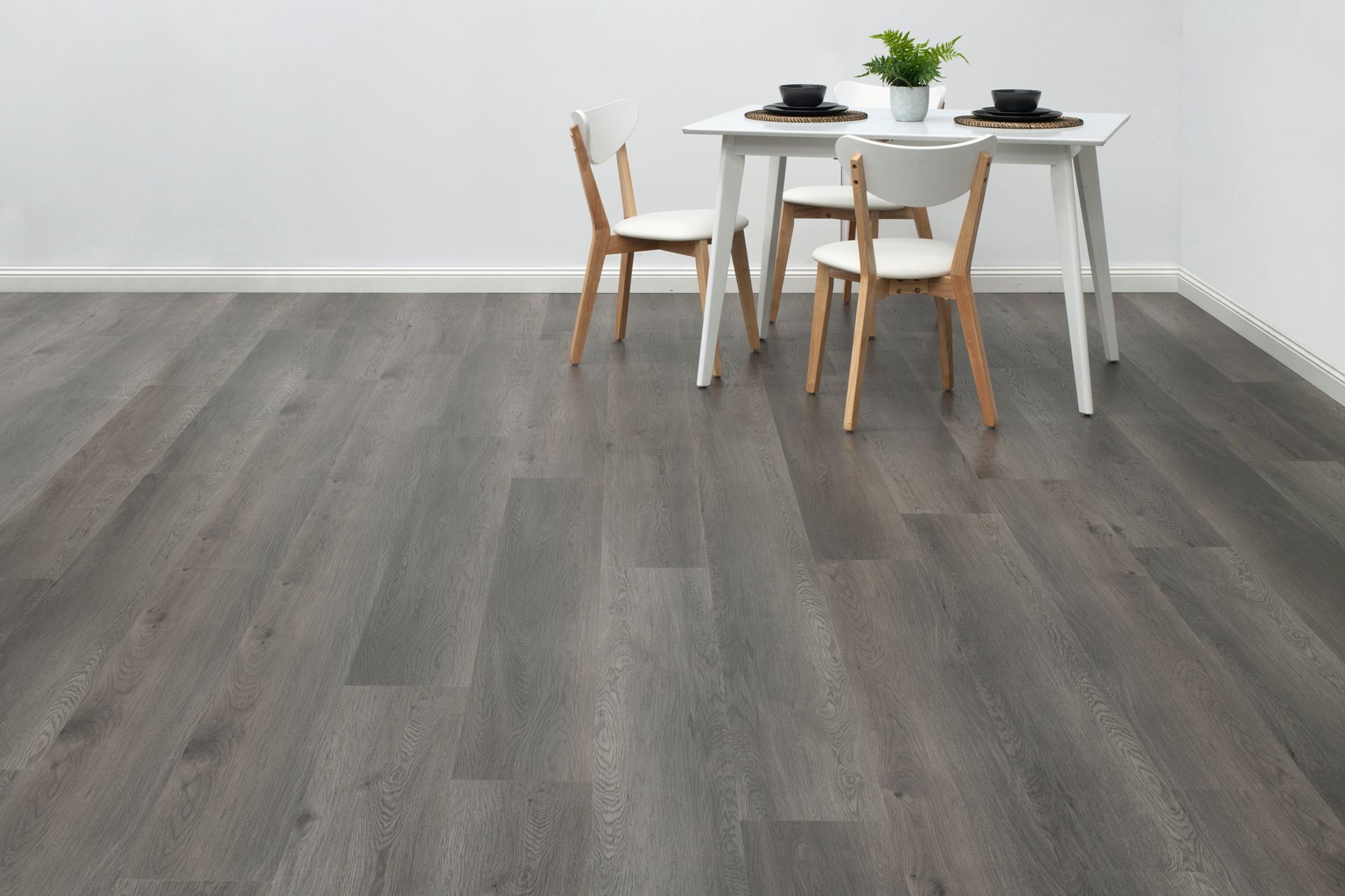 Gray Wooden Floor With a White Table and Chairs in a Minimalist Room — Hoppens Floorworld in Atherton, QLD