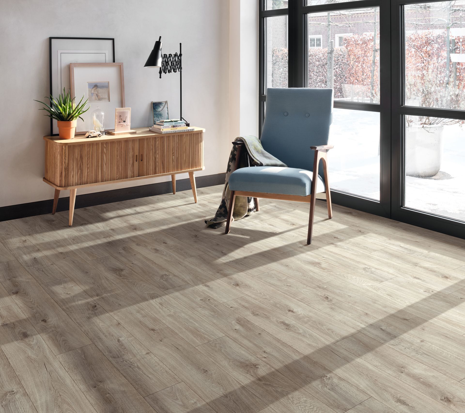 Room With Wood-look Flooring, a Blue Chair, and a Wooden Cabinet Against a Window — Hoppens Floorworld in Mooroobool, QLD