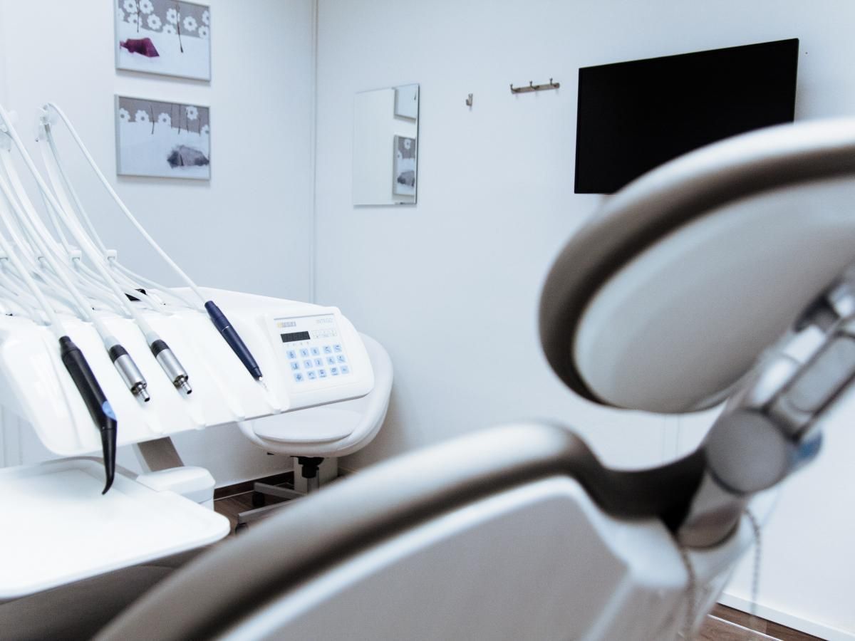 An empty dental office with a chair and a monitor