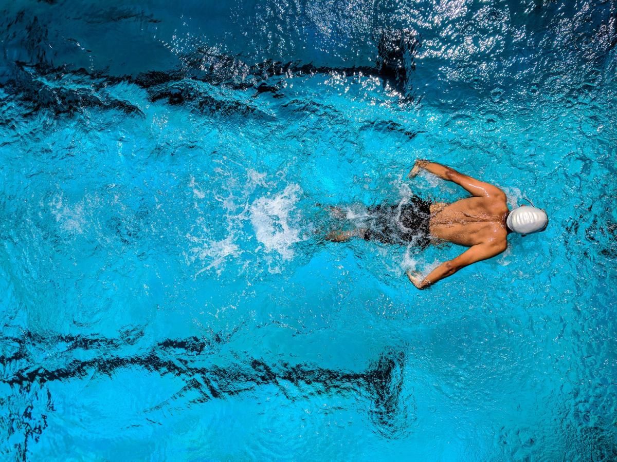 A man is swimming in a swimming pool.