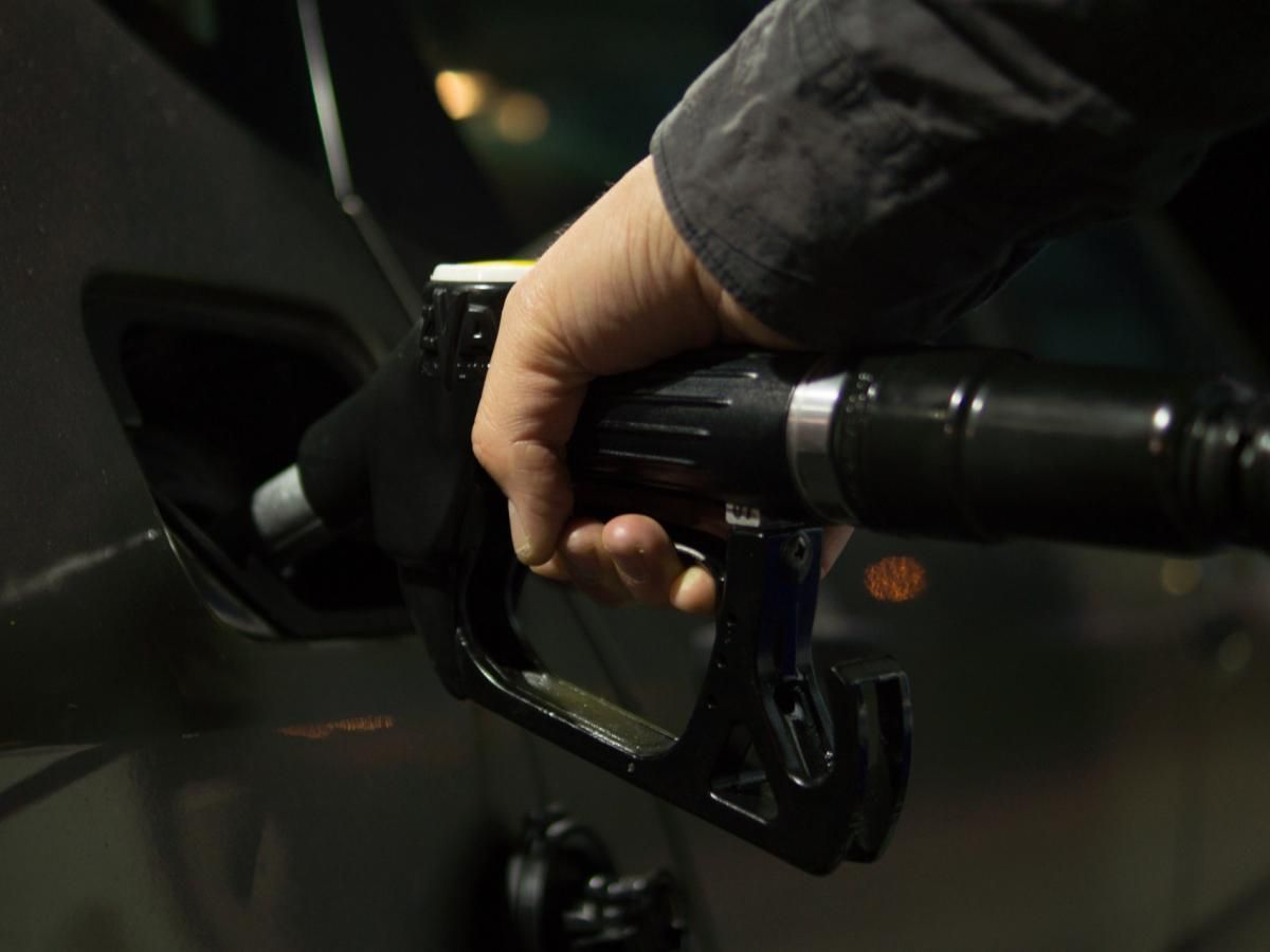 A person is pumping gas into a car at a gas station.