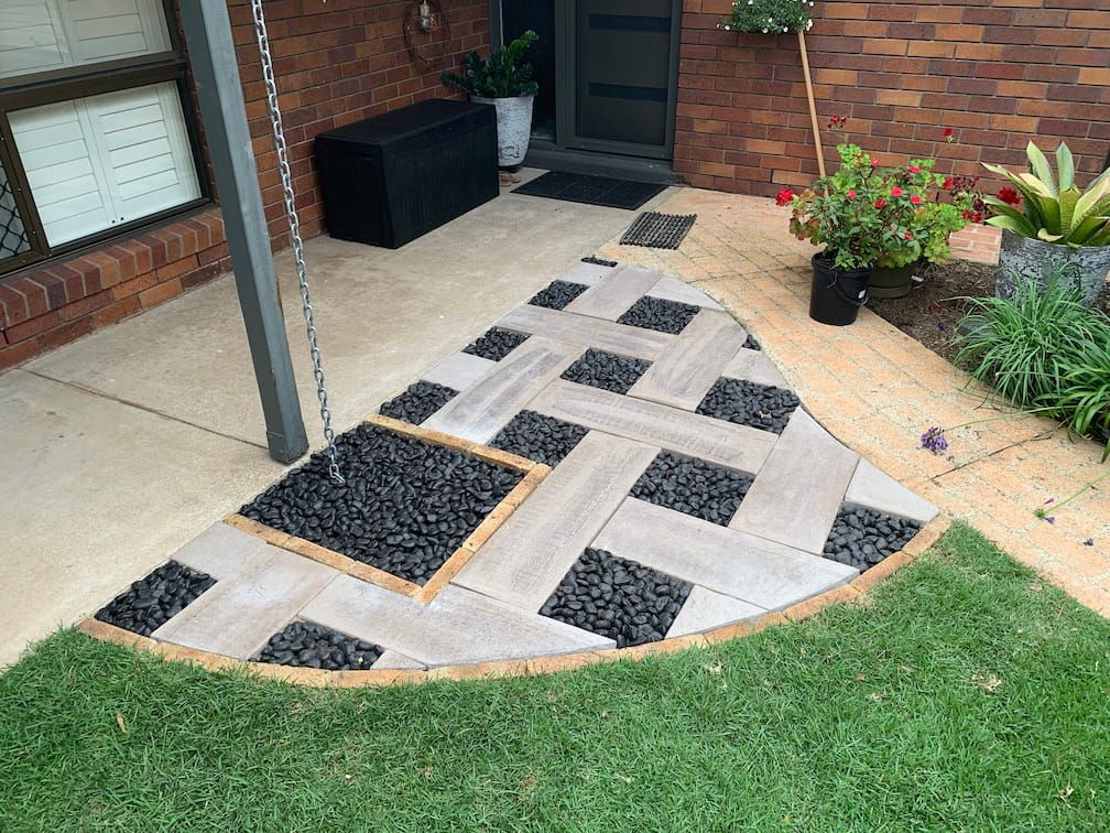 A patio with a herringbone pattern and a swing in the background.