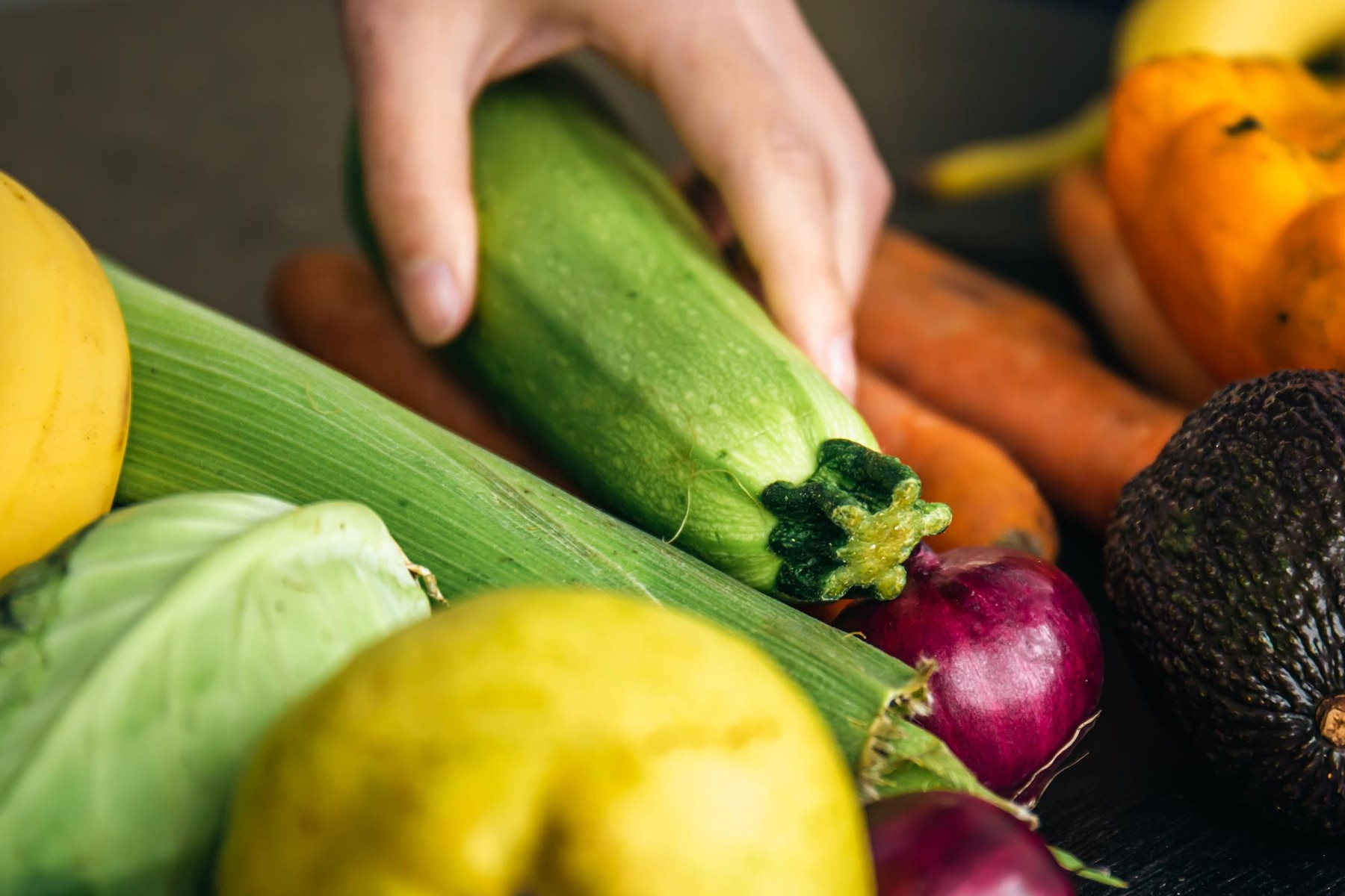 A hand on top of some vegetables