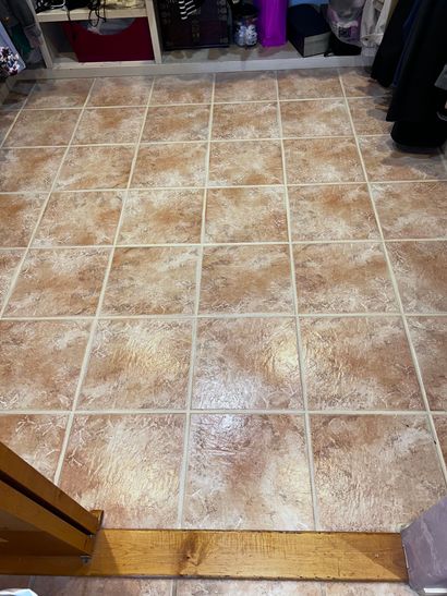 Tiled floor before-and-after: dirty grout on left, clean light grout on right