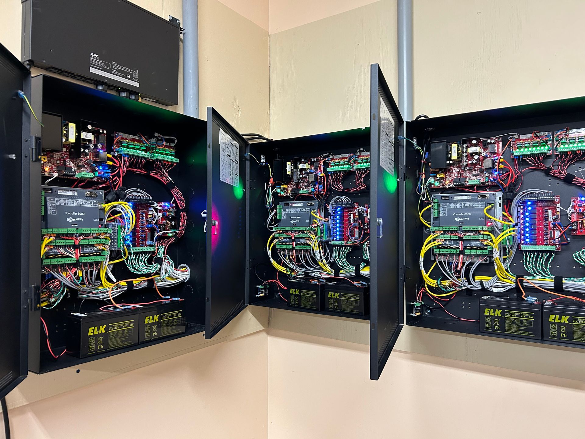 Open electrical control panels with colorful wiring and circuit boards in a room