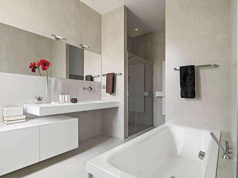 A bathroom with a bathtub , sink and mirror