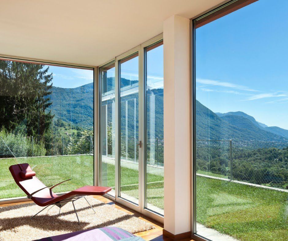 A living room with a lot of windows and a chair