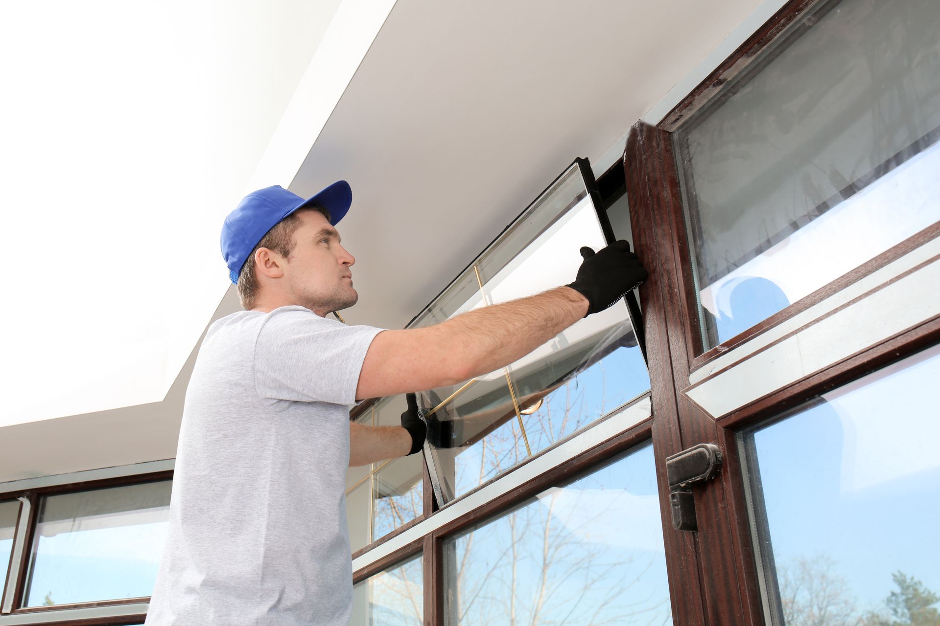 Glazier replacing a window in a house’s exterior.