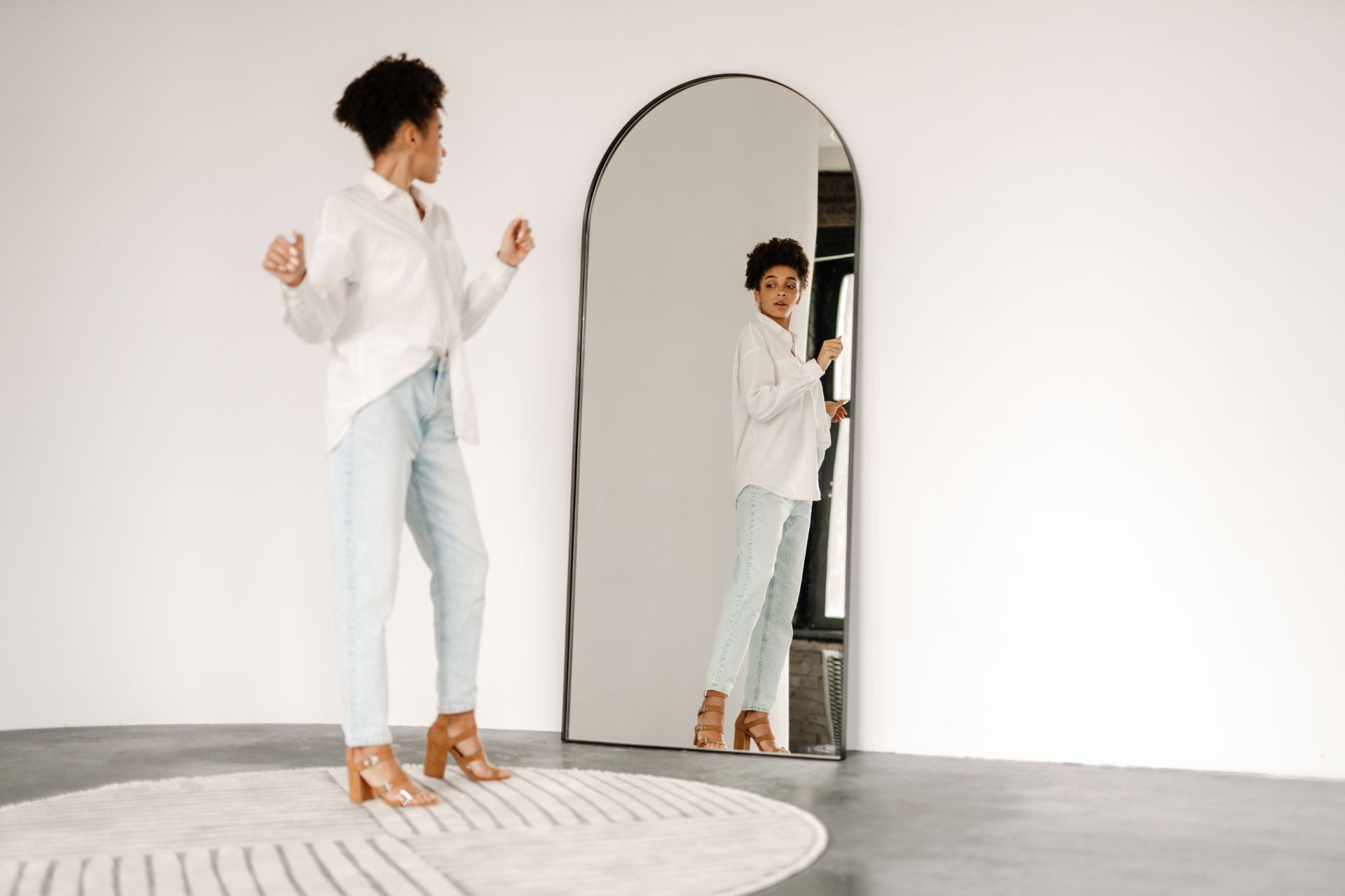Standing and looking at mirror indoors Standing and looking at mirror indoors
