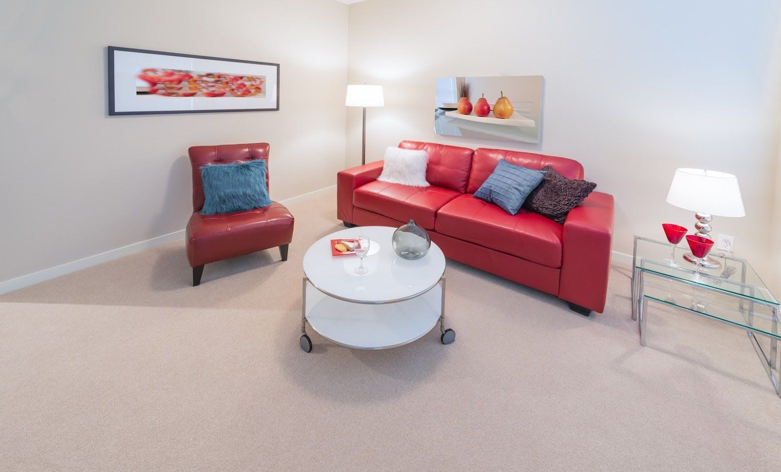 A living room with a red couch and a white coffee table