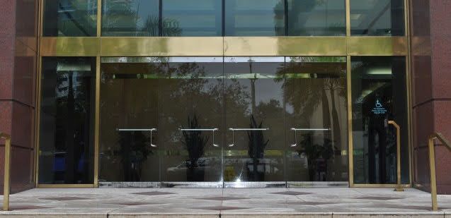 A large building with a large glass door and stairs leading up to it.