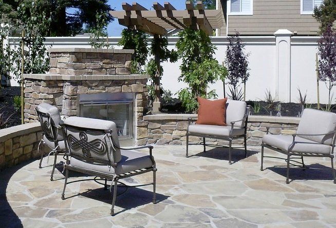 Natural stone tile patio with outdoor fireplace and elegant ring wall