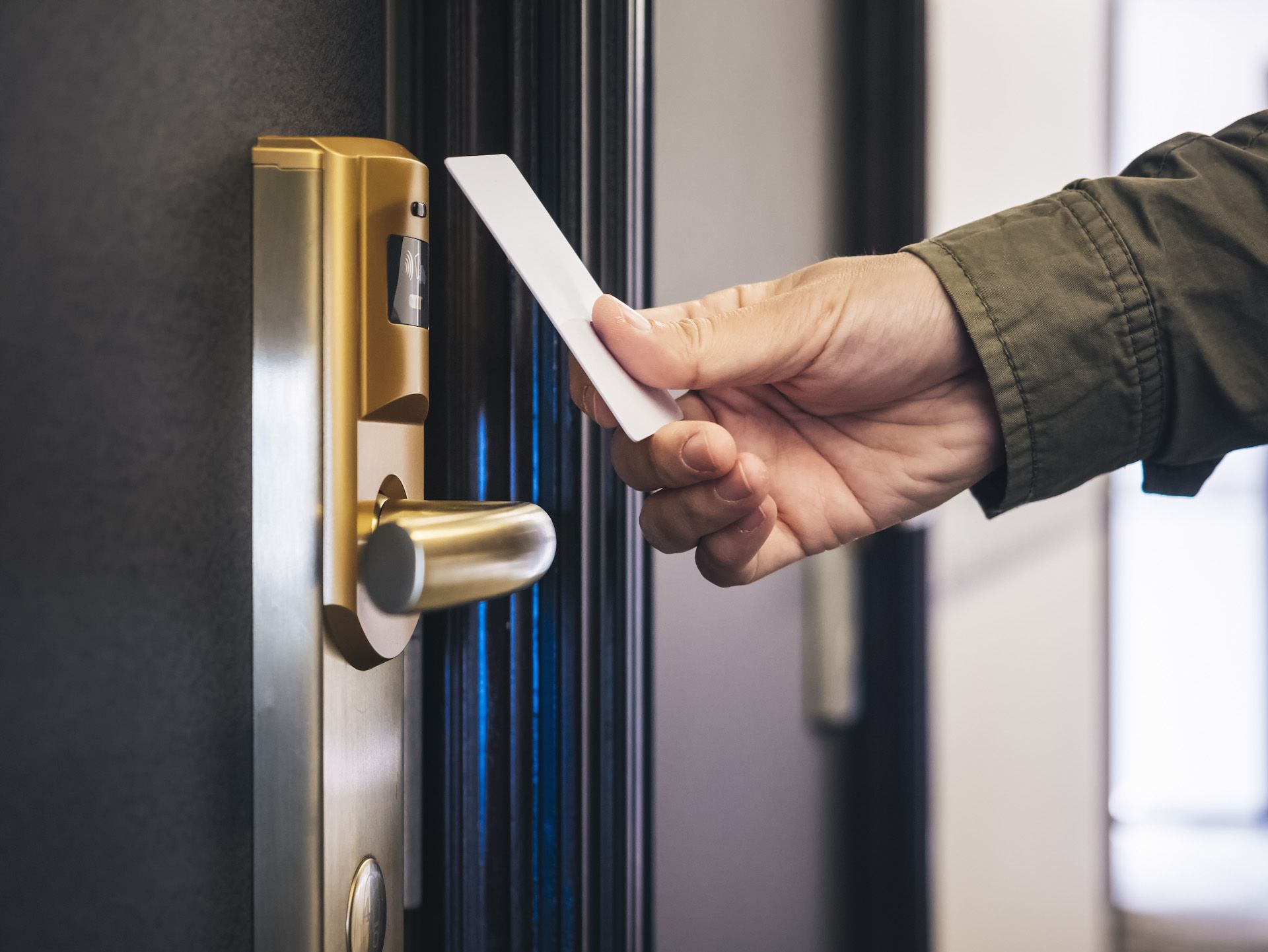A person is using a key card to open a door.