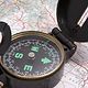 A compass is sitting on top of a map.