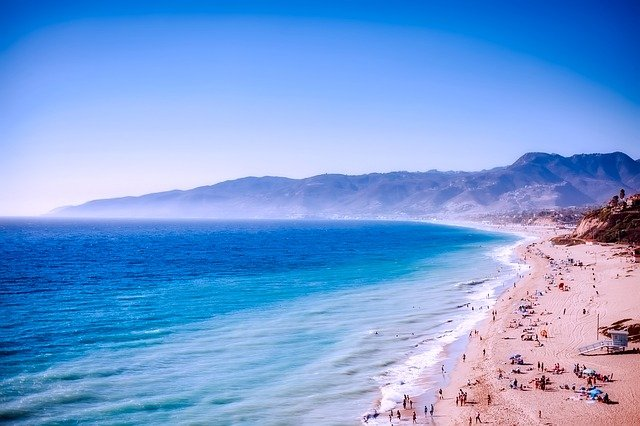 An aerial view of Malibu Beach with mountains in the background.
