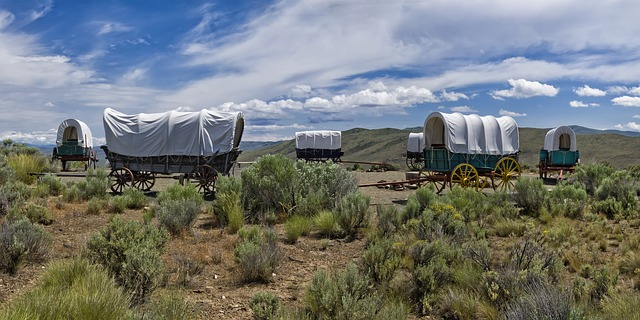 A group of covered wagons are parked in the middle of a field in Casper