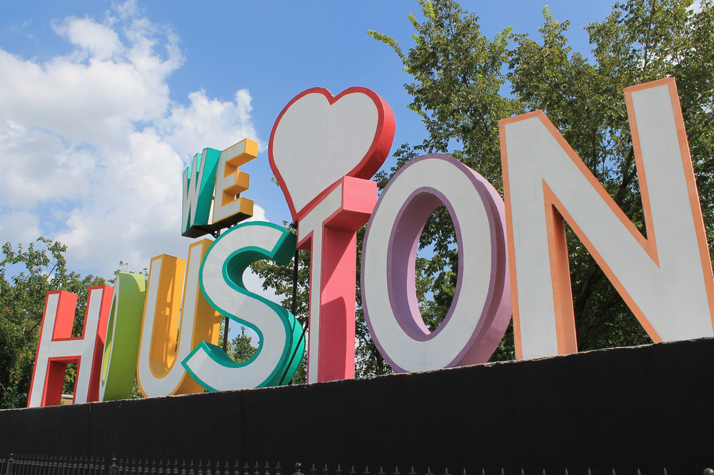 A sign that says we love houston with a heart in the middle