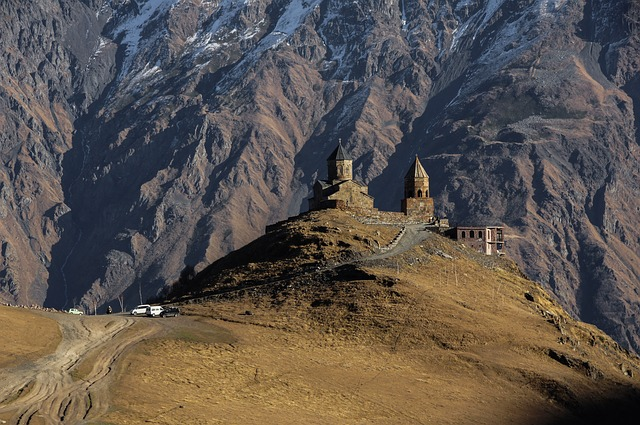 A church on top of a mountain with mountains in the background in Georgia