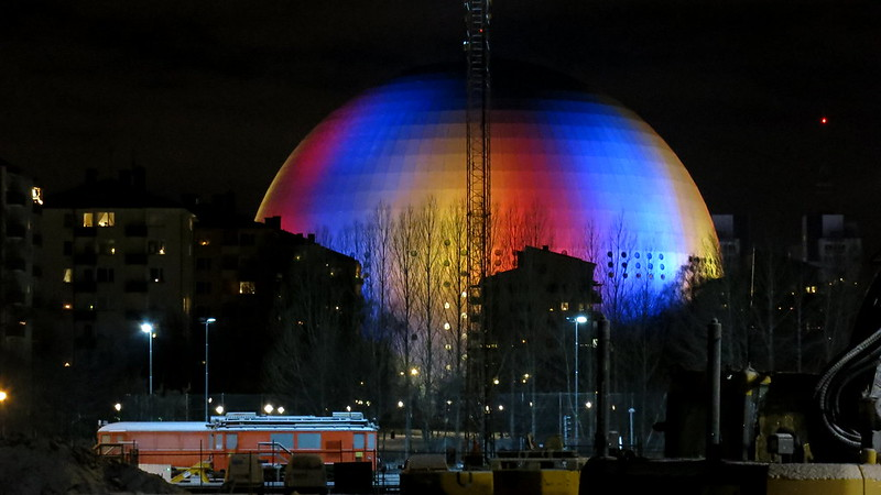 The Stockholm Globe Arena is lit up with red, blue and yellow lights